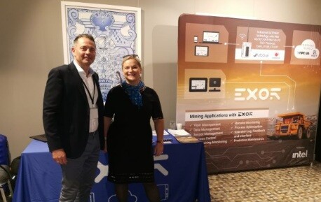 Natalia Poliakova and Carlo Sportiello standing in front of the EXOR mining-applications display stand, with an Intel logo, at the Digitization in Mining conference